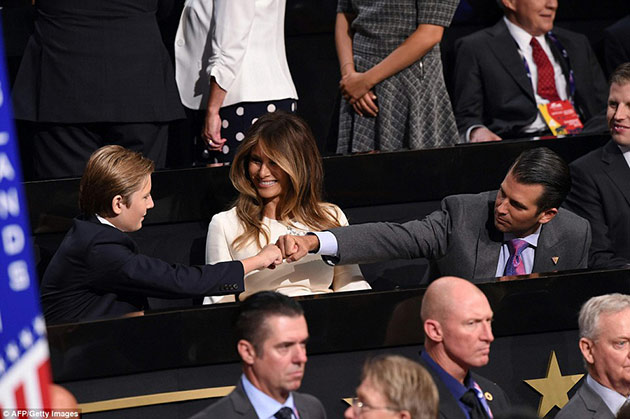 Barron Trump and Donald Trump Jr. sharing a fist punch while meeting each other.