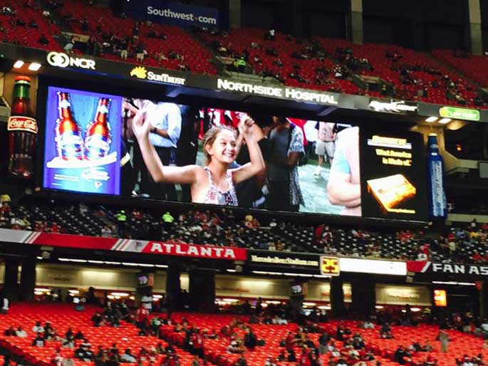 Claudia seen in big screen at the baseball game tournament.