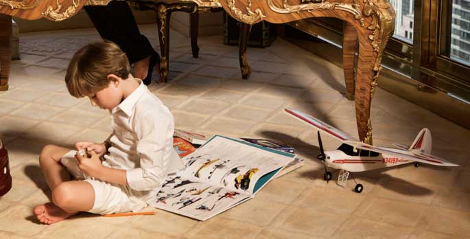 First kid Barron Trump in his room playing with his airplane toys and books.